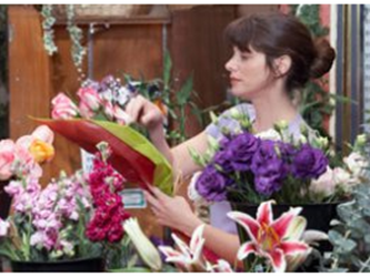 Woman putting together floral arrangements 